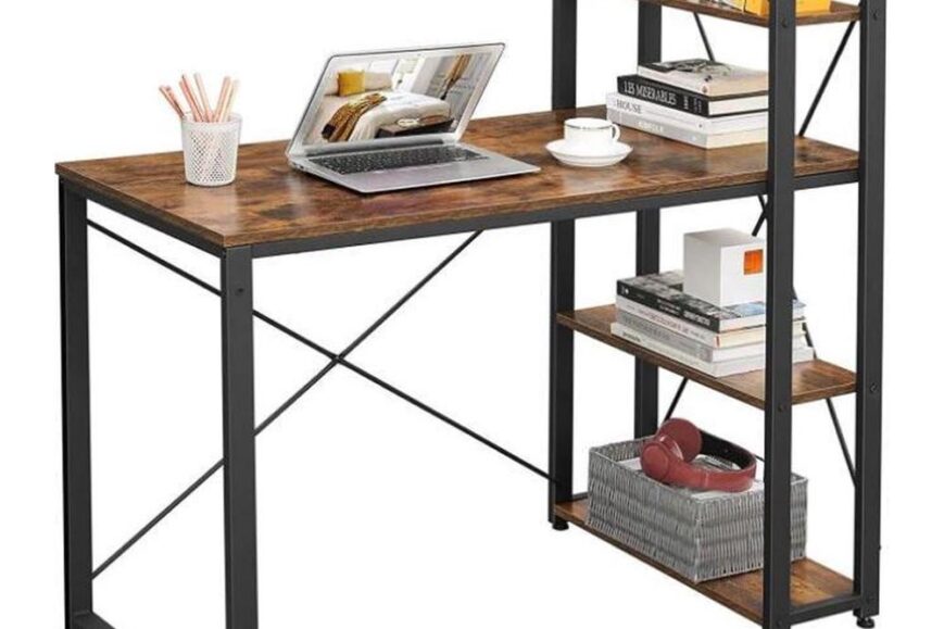 Een moderne computerbureau met een houten oppervlak en zwarte metalen poten, uitgerust met een laptop, een kopje en kantoormateriaal. Het bureau heeft tevens een open schap met boeken, een plantenpot en decoratieve items aan de rechterzijde.