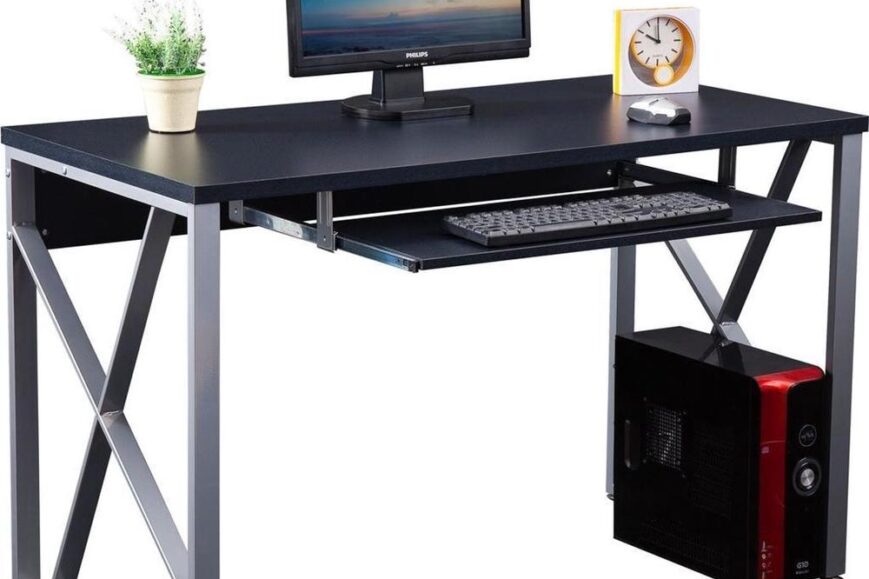 Een modern bureau met een computerbeeldscherm, toetsenbord en een stijlvolle plantenpot. Het bureau heeft een zwart blad, metalende poten en ruimte voor een desktopcomputer aan de zijkant.