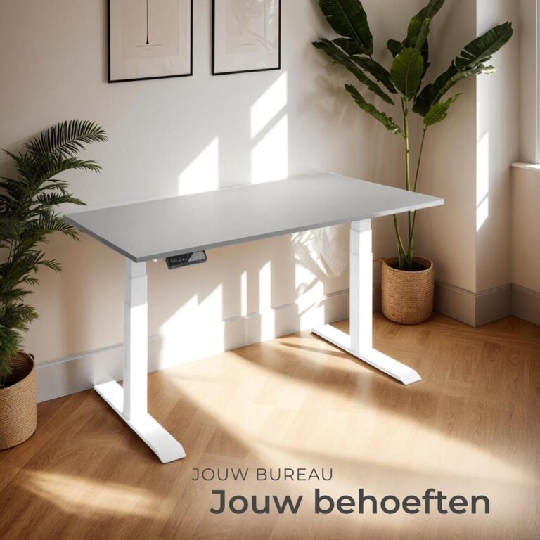 Een modern verstelbaar bureau van grijs en wit met een minimalistisch ontwerp, geplaatst in een lichte kamer met natuurlijk licht. Op de achtergrond zijn groene planten en ingelijste kunstwerken zichtbaar, wat de ruimte een frisse uitstraling geeft.