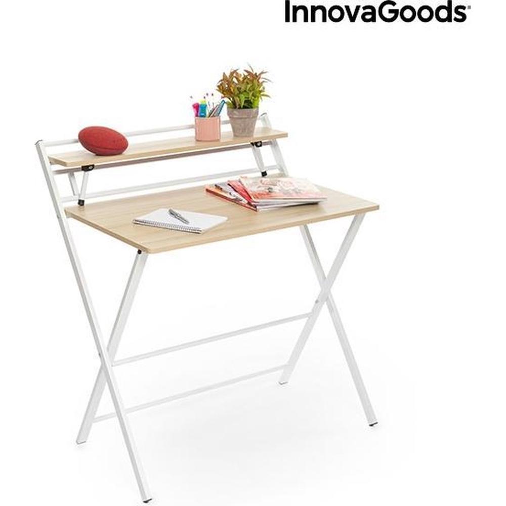 Een minimalistische bureau met een houten blad en een metalen frame in het wit. Boven het bureau staat een gemonteerd rek met pennen, een plant en tijdschriften, wat de functionaliteit en uitstraling van de werkruimte benadrukt.