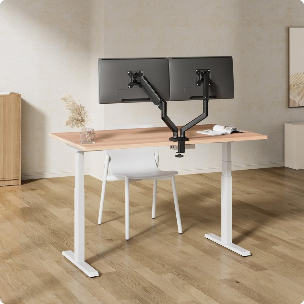 Een moderne werkplek met een minimalistisch bureau dat twee verstelbare monitoren ondersteunt, uitgerust met een zwarte monitorarm. Een witte stoel en enkele decoratieve elementen zorgen voor een nette en sfeervolle ambiance.