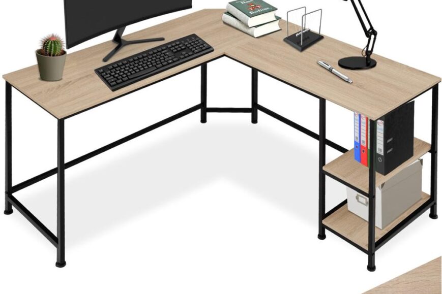 Een lichtgekleurd L-vormig bureau met een zwart frame, uitgerust met een computer, toetsenbord en een bureaulamp. Op het bureau staan ook boeken, een pen en een pot met een cactus, terwijl er aan de zijkant opslagplanken zijn met ordners en een opbergdoos.
