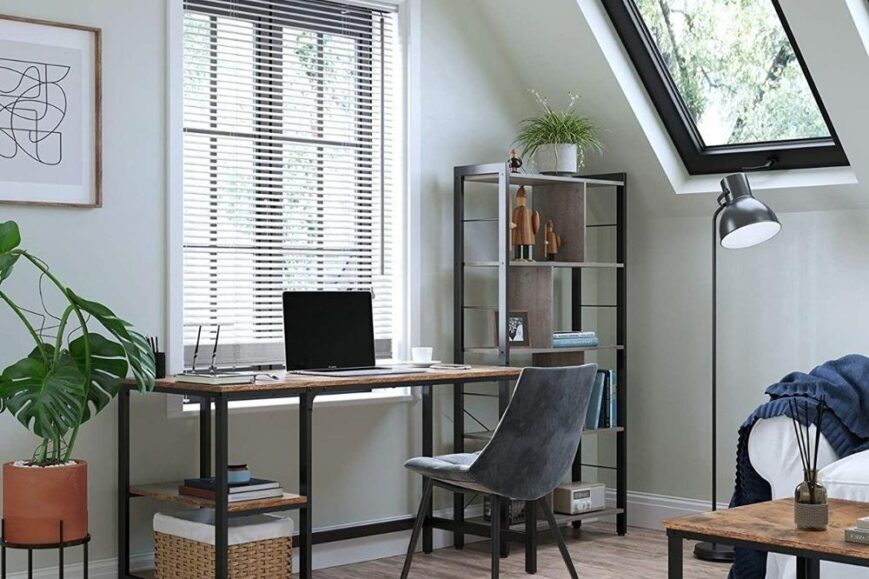 Moderne werkomgeving met een houten bureau, een grijze stoel en een laptop. Een grote raam met jaloezieën biedt natuurlijk licht, terwijl een plantenpot en een boekenkast de ruimte aanvullen.